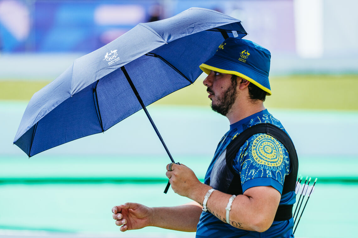 Peter Boukouvalas holding an umbrella at Paris 2024.